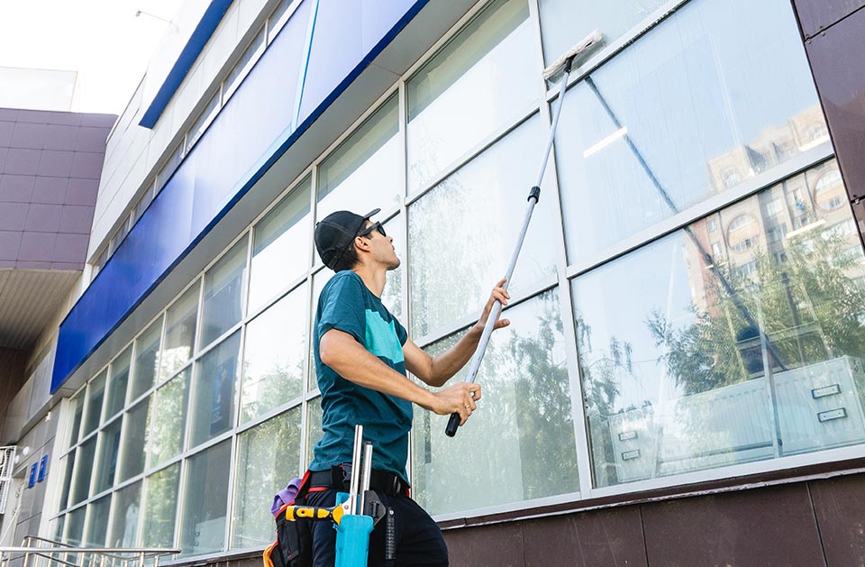 ein Fensterputzer reinigt die Außenfenster